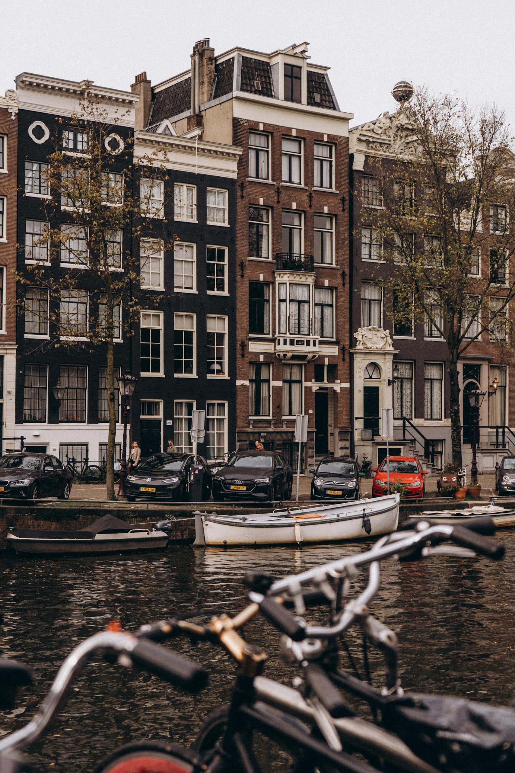 Quaint view of Amsterdam canal houses with bicycles in the foreground, capturing the city's charm.